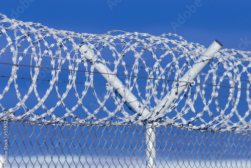 Barb wire roll on a fence with dark blue clouds in the background