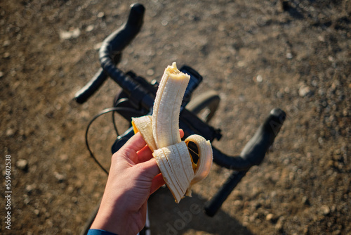 Banana on bicycle background. Cyclist eating banana. Healthy nutrition of a cyclist. Healthy snack for a cyclist during training.