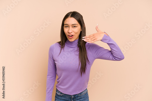 Young colombian woman isolated on beige background laughing about something, covering mouth with hands.