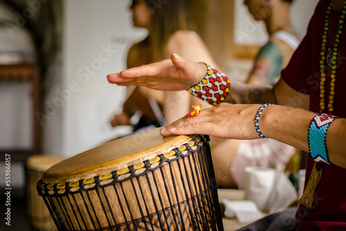 Sao Paulo, SP, Brazil - December 31 2022: Person with traditional Indian bracelets and rings playing djembe details.