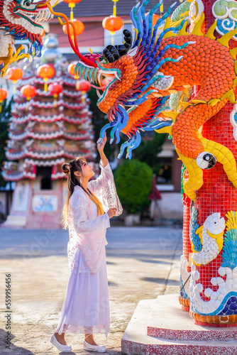 Portrait cute Asian girl wearing Chinese costumes for Chinese new year festival celebrate culture of china at Chinese shrine Public places in Thailand, People traveling lifestyle at outdoor.