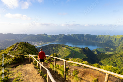 Hiker in a red jacket at the caldera on São Miguel island in the Azores