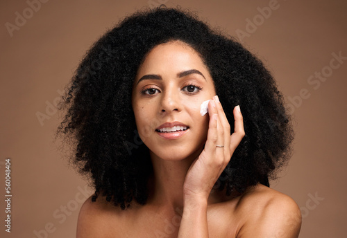 Face, cream and black woman in studio for skincare, beauty and cosmetics promotion with product application in portrait. African model with skin care, dermatology and sunscreen wellness in a headshot