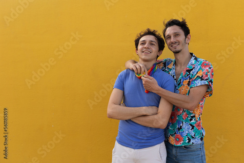 Happy young couple embraces. Two men enjoy outside.