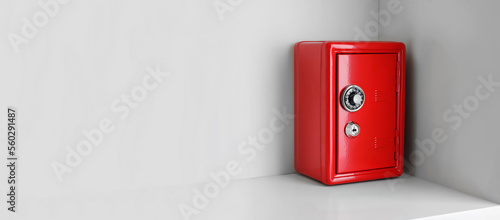 Red steel safe with mechanical combination lock on shelf, space for text. Banner design