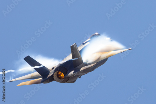 Very unusual close view of a F-35A Lightning II in a high G maneuver , with condensation clouds around the plane and afterburner on