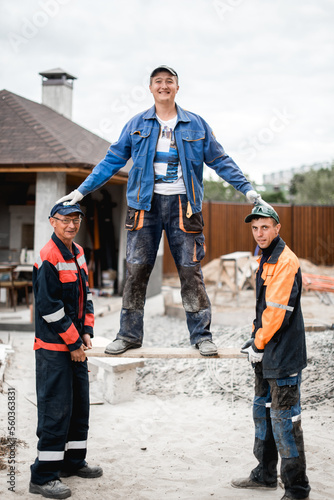 business, building, teamwork and people concept - group of smiling builders outdoors