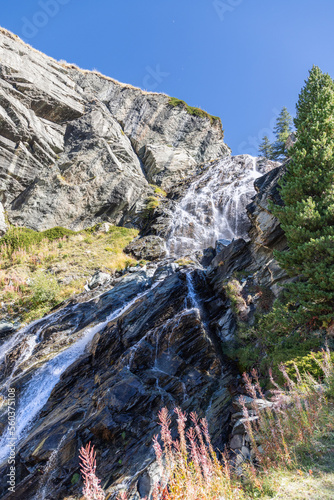 Lillaz waterfall (Cascate di Lillaz) wash around granite karst rapids of rock in Gran Paradiso National Park, Aosta, Italy (vertical shot)