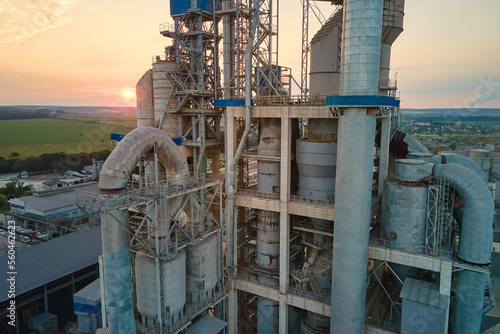 Cement plant with high factory structure and tower cranes at industrial production area. Manufacture and global industry concept