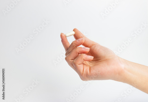 Hand holding a tablet on a white background, supplementation and health, physical and mental health concept