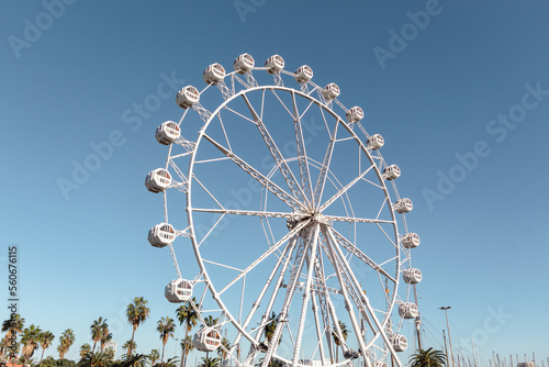 Atracción de la noria en el paseo marítimo de Barcelona en una feria puesta al lado del puerto con turistas de todo el mundo paseando por allí.