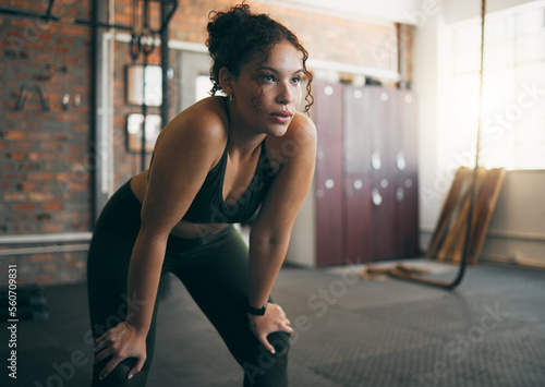 Tired, exercise and woman at gym after fitness workout or training for health and body wellness. Young sports female or athlete resting on break while thinking about goals, progress and performance