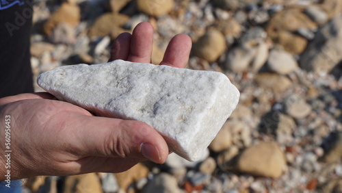 2000 years old piece of white marble in archeologist hand. Caesarea Maritima National Park
