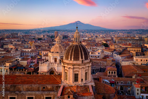 Aerial view of the Catania Saint Agatha's Cathedral by sunset with Mount Etna in the background - Sicily, Italy