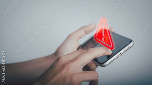 Triangle caution warning sign on laptop screen and Businessman or it staff , programmer, developer using smartphone for notification problem error 404 and maintenance concept.