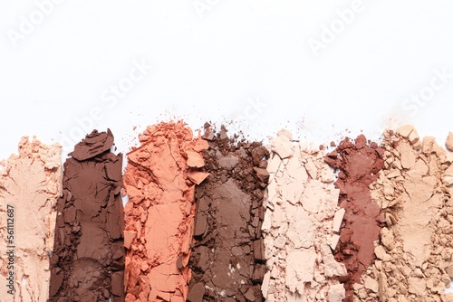 Crushed eye shadows on white background, top view. Professional makeup product