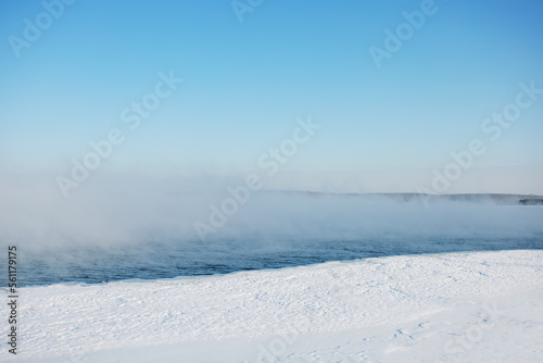  global warming concept. melting ice and steam rises over sea bay.