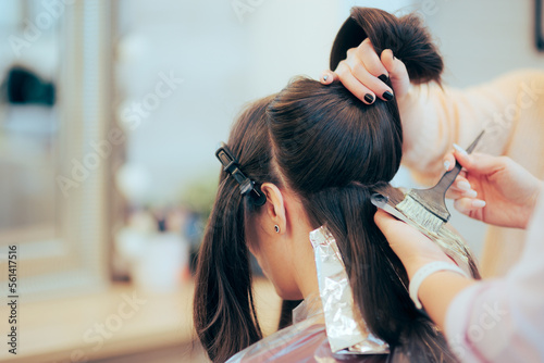 Hairdresser Sectioning and Dying the Hair of a Client. Woman changing her hair style and color in a professional salon 