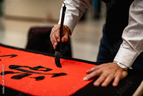 Writing Chinese calligraphy with word meaning "Good Fortune" for Taditional Chinese new year