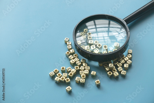 Learning and education concept. Finding keywords. Language learning. Magnifying glass on a bunch of alphabet beads.
