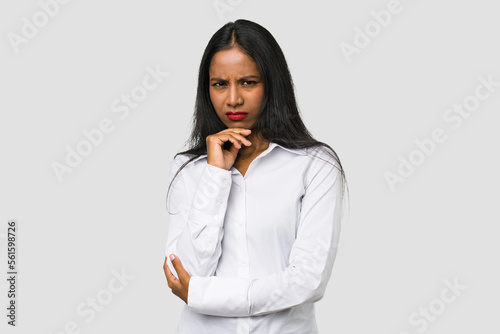 Young Indian woman cut out isolated on white background suspicious, uncertain, examining you.