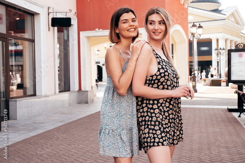 Portrait of two young beautiful smiling hipster female in trendy summer dress clothes.Sexy carefree women walking on street background. Positive models having fun, hugging