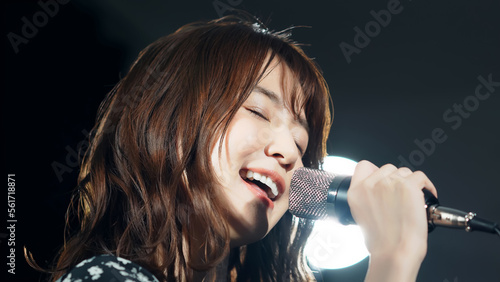スポットライトを浴びて歌う女性 ライブ コンサート カラオケ