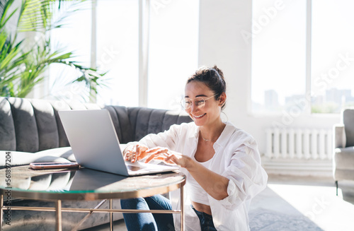 Content woman working on laptop in living room