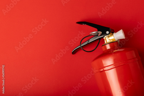 Fire extinguisher on the background of a red wall. Fire protection, home fire extinguisher. home security concept. Place for text. Copy sleep.