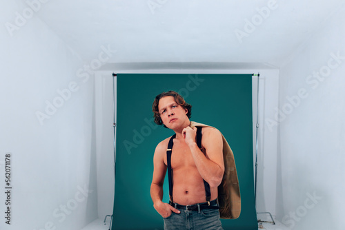 studio portrait of shirtless man acting against grey key background - young actor in audition or screen test