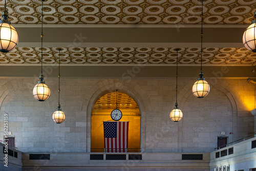 Interior of train station in New Haven with brick wall, decorative ceiling, and lamps