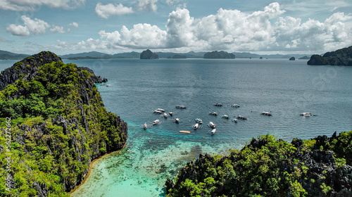 Catamarans at The Big Lagoon In El Nido, Palawan, Philippines. Kayaking In Shallow Crystal Clear Water, Turquoise Colored Reef, Bright Green Tree Covering Cliffs