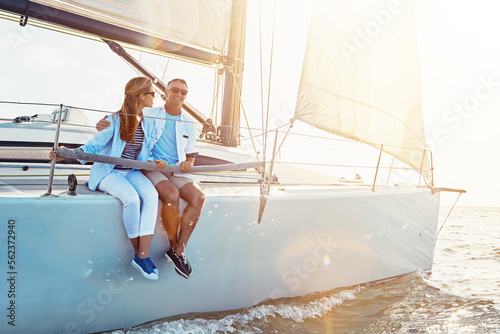 Couple, yacht cruise and relax on ocean for sunset travel holiday, summer vacation or quality time together. Luxury sailing adventure, man and woman bonding and happy for love or outdoor lifestyle