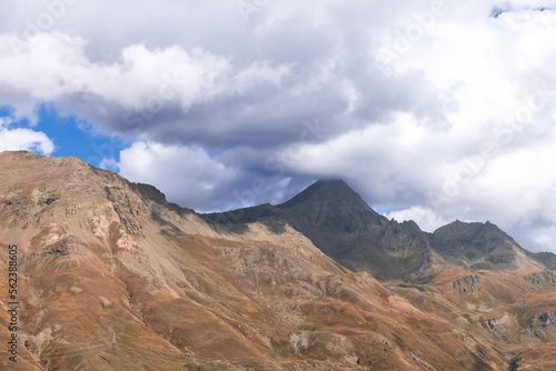 Panoramic shot of autumn yellowed slopes of alpine peaks in Gran Paradiso National Park. Aosta Valley, Italy