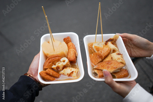 Couple hand holding Japan famous street food "Oden" with isolated blur background