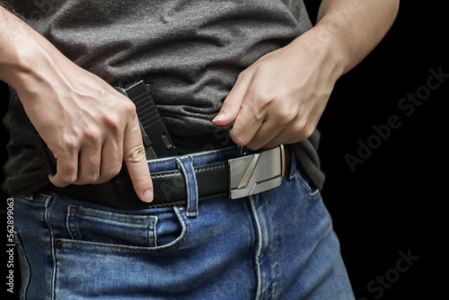 Man drawing a conceal carry pistol from a holster