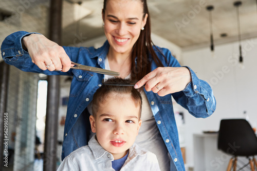 Mutter beim Haare schneiden von Kind zu Hause