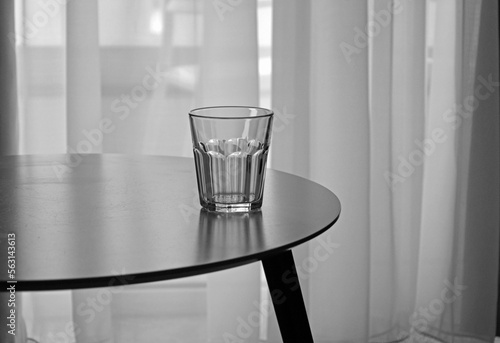 pusta szklanka na stole, empty glass, empty glass on the table in an empty room