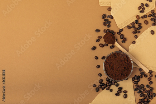 Coffee filter with ground coffee powder on a brown background. fragrant coffee beans for an energizing and invigorating drink. Hand Drip Coffee, Flat Lay of Manual Brew Coffee Tools