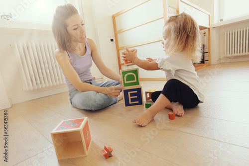 Mother and daughter play with wooden cubes