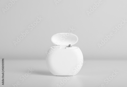 Container with dental floss on white background