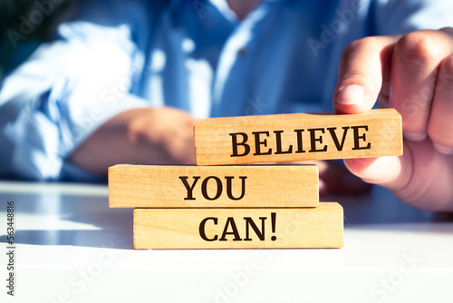 Close up on businessman holding a wooden block with "Believe you Can" message