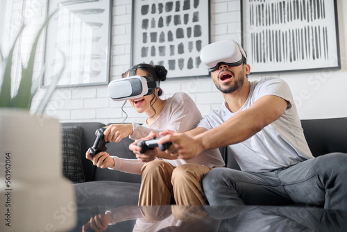 Virtual reality, gaming and metaverse with a couple playing video games in their home together for fun or enjoyment. VR, game and 3d ai with a man and woman gamer bonding in a house living room