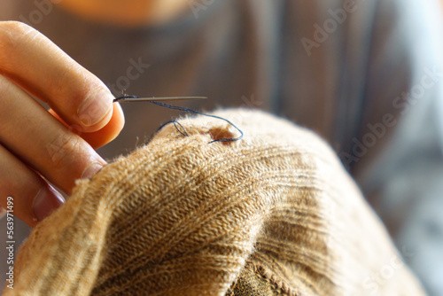 Mending clothes. Old worn woolen clothes. Repair concept, selective focus