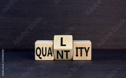 Quality and quantity symbol. Concept word Quality Quantity on wooden cubes. Beautiful black table black background. Business and quality and quantity concept. Copy space.