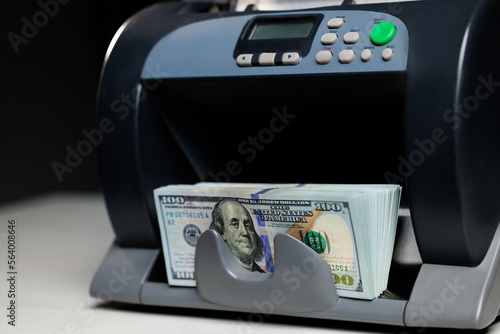 Closeup of cash counting machine counting dollar bills. Business accounting and commercial activity, american monetary units. Counting machine with US national cash money