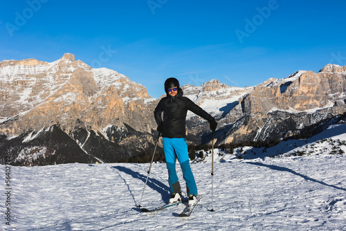  A young man, a happy skier, admires the Italian Dolomites mountains. Skiing, winter sports. Młody mężczyzna, szczęśliwy narciarz podziwia włoskie góry Dolomity. Narty, sporty zimowe.