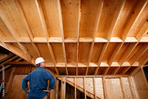 Inspector checking out attic and support beams of home addition project.