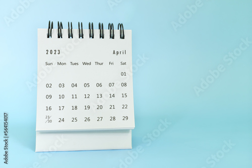 Selective focus of April 2023 desk calendar on blue background with copy space.