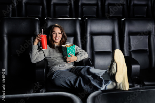 A happy young woman in a VIP cinema where there are no people. Film premiere